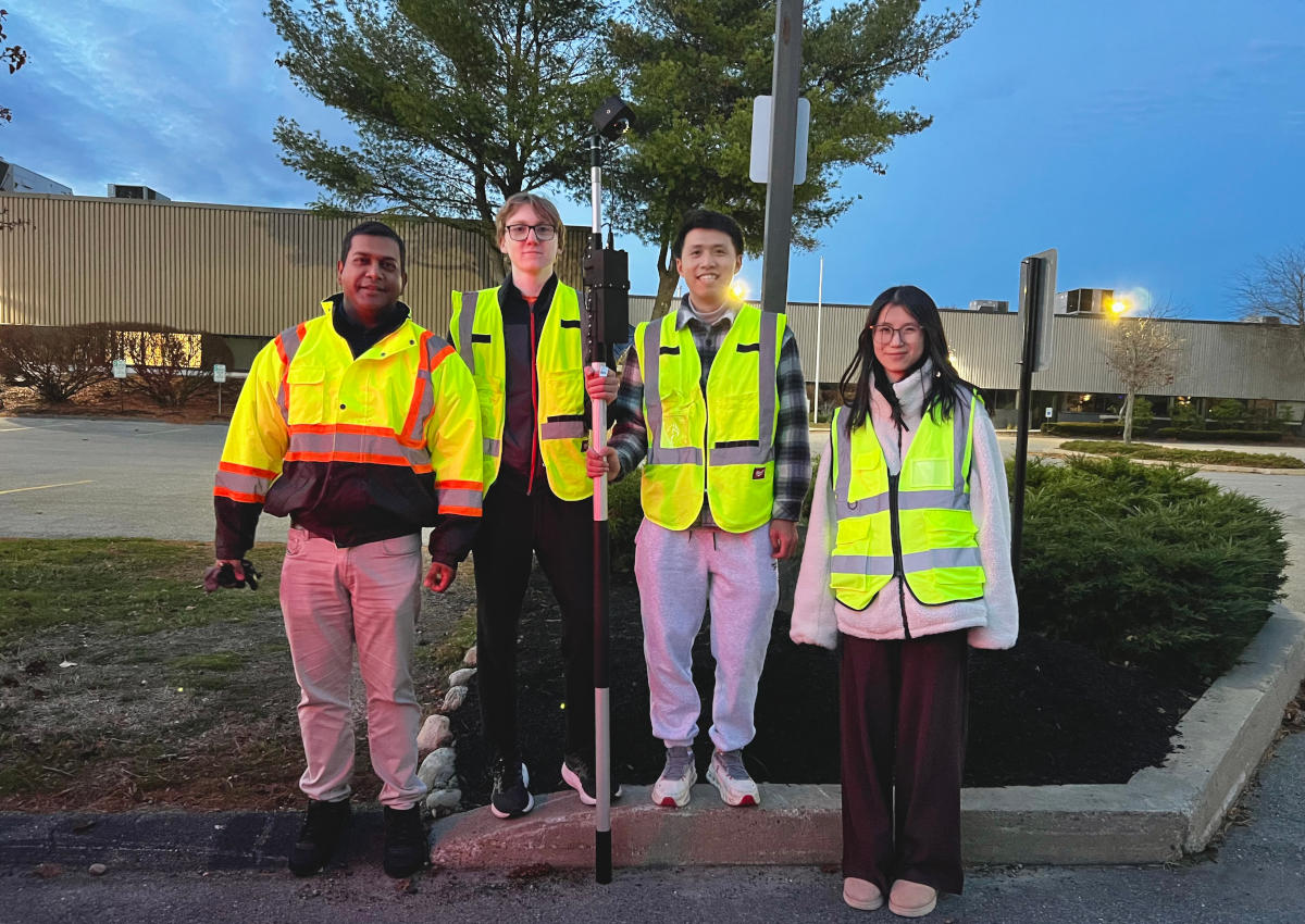 Project team standing with installed portable camera and battery systems during a field deployment