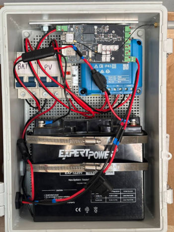 Image of a field-deployed cabinet housing the microcontroller, battery, and photovoltaic charge controller for the LED warning sign. The unit communicates wirelessly via Wi-Fi or LoRaWAN with a separate edge cabinet that contains the deep learning module and integrated thermal and RGB camera system.